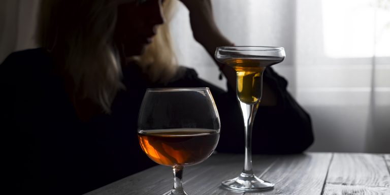 silhouette of anonymous alcoholic woman person drinking behind glass of alcohol. Alcohol addiction and Social problem - with alcoholism and poisoning